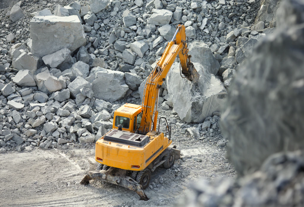 Excavator loading rock at a quarry face